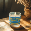 Handmade 14oz soy wax game day candle in frosted glass jar with team colors and label reading “Smells Like a [Team Name] Win.”