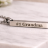 Stainless steel engraved bar necklace with custom name engraving shown with the message #1 Grandma