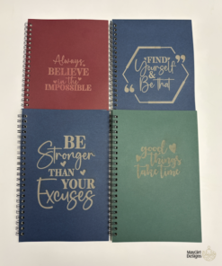 Set of custom spiral journals in assorted colours with engraved motivational sayings on the covers.