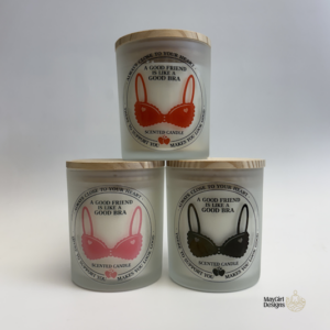 Set of frosted glass scented candles with funny bra-themed friendship labels in pink, red, and black designs