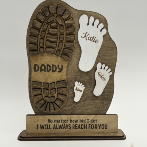 Personalized wooden Father’s Day keepsake sign with a large daddy boot print, three children’s footprints, engraved names, and the message “No matter how big I get, I will always reach for you.”