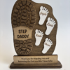 Personalized wooden Father’s Day keepsake sign with a large daddy boot print, three children’s footprints, engraved names, and the message “No matter how big I get, I will always reach for you.”