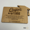 Custom wooden graduation money holders with engraved Class of designs, including cap and diploma details.